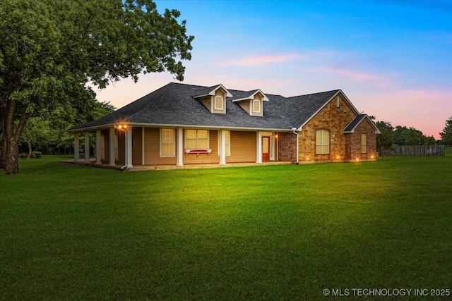 2259 E Rodeo Rd, Durant, OK 74701 - view of front of home with a front yard, a porch, brick siding, and a shingled roof