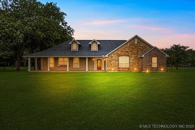 2259 E Rodeo Rd, Durant, OK 74701 - view of front of property with a lawn, a porch, roof with shingles, and stone siding