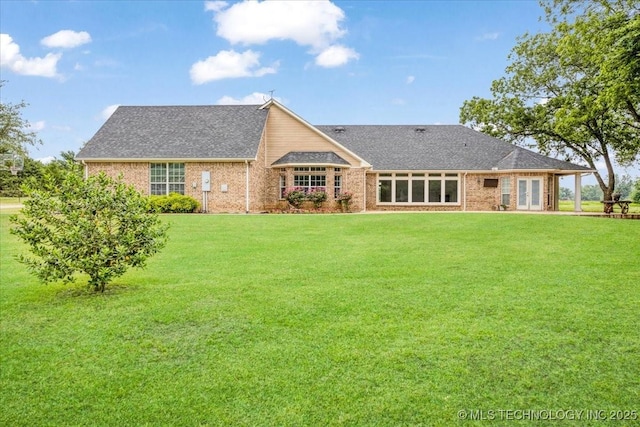 2259 E Rodeo Rd, Durant, OK 74701 - rear view of house featuring a yard, french doors, roof with shingles, and brick siding