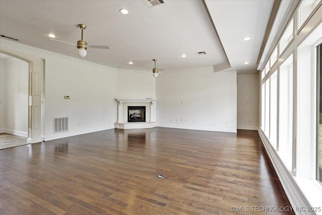 2259 E Rodeo Rd, Durant, OK 74701 - unfurnished living room with a ceiling fan, dark wood-type flooring, baseboards, a fireplace with raised hearth, and crown molding