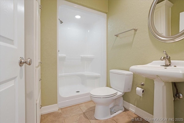 2259 E Rodeo Rd, Durant, OK 74701 - full bathroom featuring toilet, a shower, tile patterned floors, and baseboards