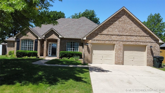 7604 N 127th E Ave, Owasso, OK 74055 - french country inspired facade featuring an attached garage, concrete driveway, a front yard, and brick siding