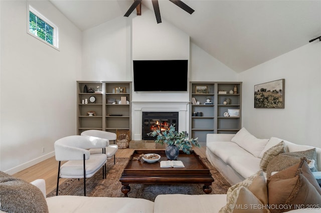8721 S 65th E Pl, Tulsa, OK 74133 - living room with wood finished floors, a ceiling fan, a glass covered fireplace, high vaulted ceiling, and baseboards