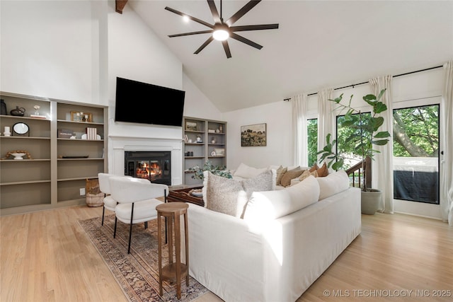 8721 S 65th E Pl, Tulsa, OK 74133 - living area featuring high vaulted ceiling, a ceiling fan, light wood-style flooring, a glass covered fireplace, and beamed ceiling