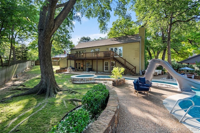 8721 S 65th E Pl, Tulsa, OK 74133 - back of property with stairway, a deck, an in-ground hot tub, a chimney, and a fenced backyard