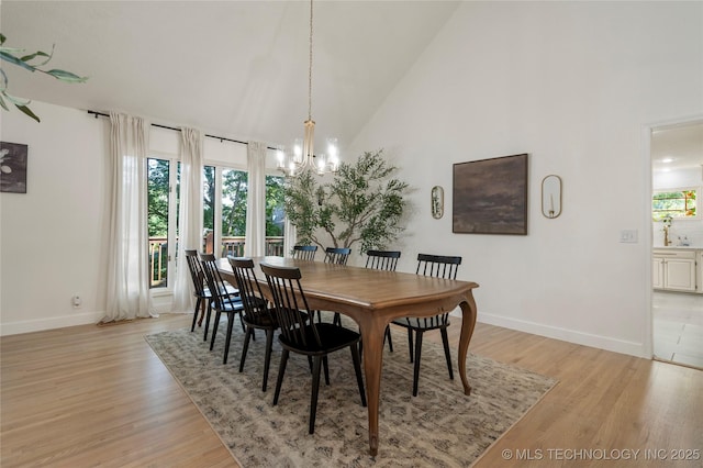8721 S 65th E Pl, Tulsa, OK 74133 - dining area with a chandelier, baseboards, high vaulted ceiling, and light wood-style flooring