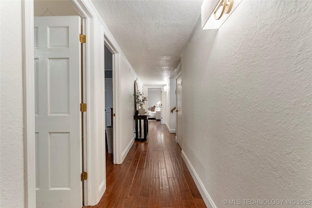 8721 S 65th E Pl, Tulsa, OK 74133 - hall with a textured ceiling, dark wood finished floors, a textured wall, and baseboards