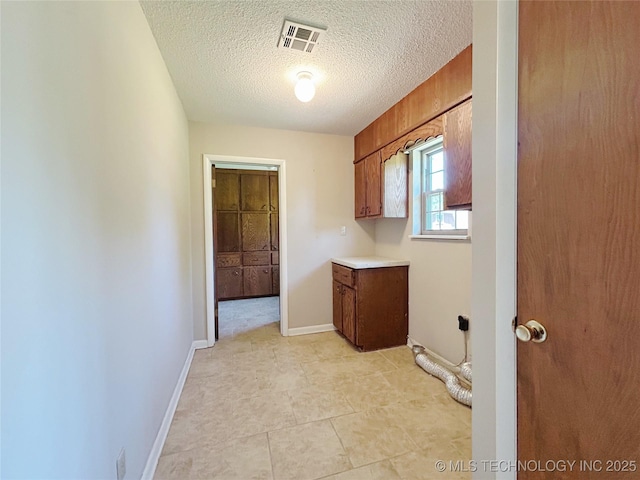 502 W Elm St, Henryetta, OK 74437 - laundry area featuring cabinet space and a textured ceiling