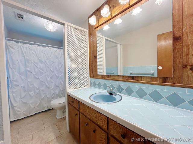502 W Elm St, Henryetta, OK 74437 - bathroom with vanity, tile patterned flooring, a shower with shower curtain, and tasteful backsplash