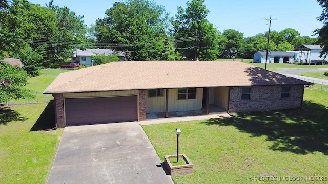 502 W Elm St, Henryetta, OK 74437 - ranch-style house with brick siding, concrete driveway, an attached garage, and a front lawn