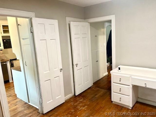2201 Baugh St, Muskogee, OK 74403 - unfurnished office featuring dark wood finished floors, built in study area, and baseboards
