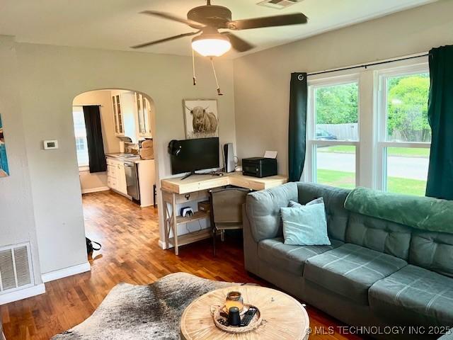 2201 Baugh St, Muskogee, OK 74403 - living area featuring arched walkways, ceiling fan, wood finished floors, and baseboards