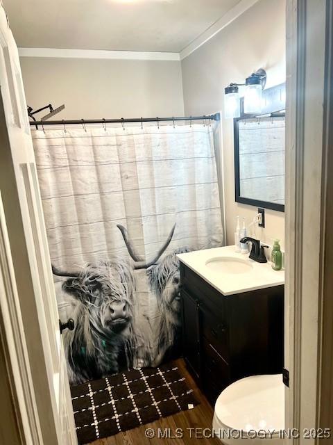 2201 Baugh St, Muskogee, OK 74403 - bathroom with ornamental molding, vanity, a shower with curtain, wood finished floors, and toilet