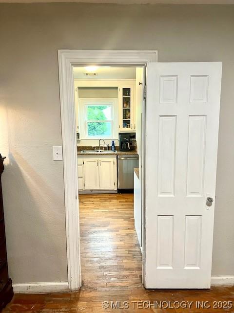 2201 Baugh St, Muskogee, OK 74403 - hallway with light wood finished floors, baseboards, and a sink
