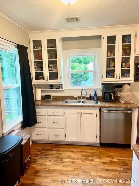 2201 Baugh St, Muskogee, OK 74403 - kitchen with dishwasher, a sink, white cabinetry, light wood-type flooring, and glass insert cabinets