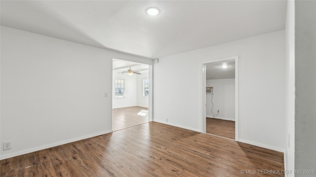 416 S Cedar St, Owasso, OK 74055 - spare room with wood finished floors, baseboards, a ceiling fan, and an AC wall unit