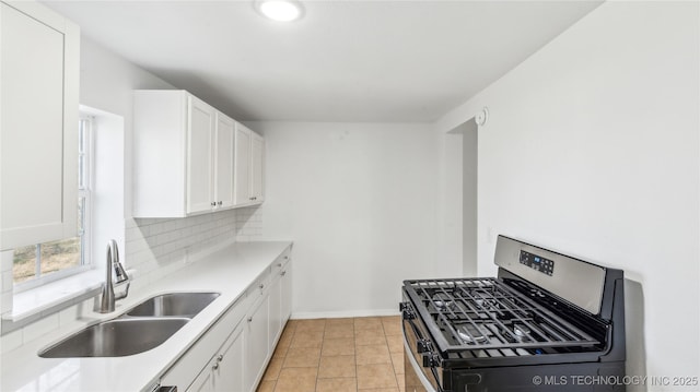 416 S Cedar St, Owasso, OK 74055 - kitchen featuring a sink, stainless steel range with gas cooktop, tasteful backsplash, and white cabinets