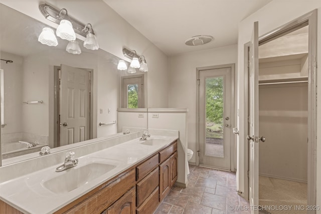 4157 New Prue Rd, Sand Springs, OK 74063 - bathroom with toilet, double vanity, stone finish flooring, and a closet