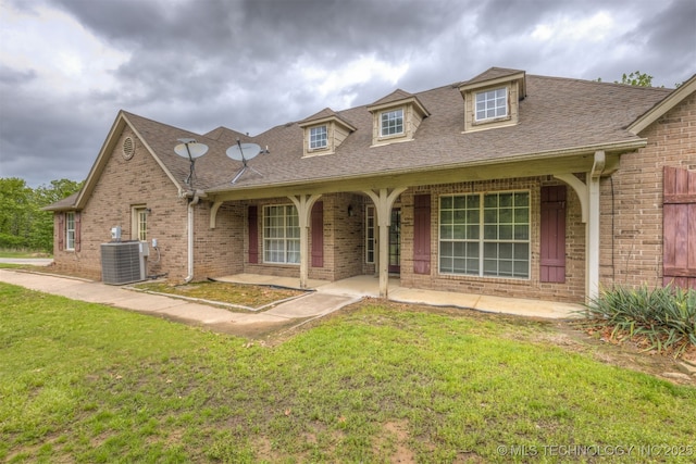 4157 New Prue Rd, Sand Springs, OK 74063 - view of front of house with cooling unit, brick siding, a front yard, and a shingled roof