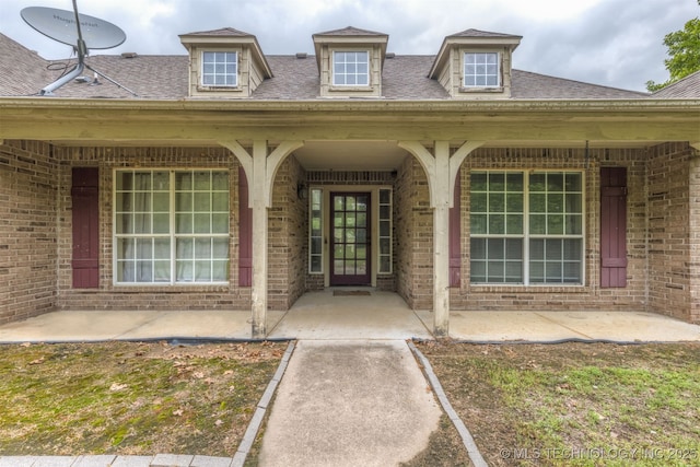 4157 New Prue Rd, Sand Springs, OK 74063 - entrance to property with brick siding, a porch, and a shingled roof