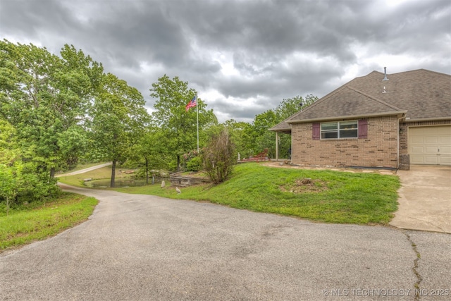 4157 New Prue Rd, Sand Springs, OK 74063 - view of side of home with brick siding, a shingled roof, concrete driveway, a lawn, and an attached garage