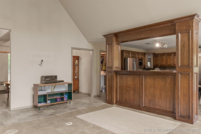 4157 New Prue Rd, Sand Springs, OK 74063 - kitchen featuring stainless steel appliances, baseboards, high vaulted ceiling, brown cabinets, and glass insert cabinets