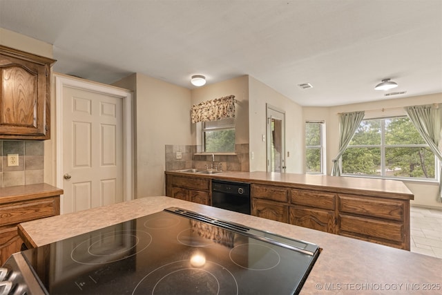 4157 New Prue Rd, Sand Springs, OK 74063 - kitchen with a sink, tasteful backsplash, brown cabinets, black appliances, and light countertops