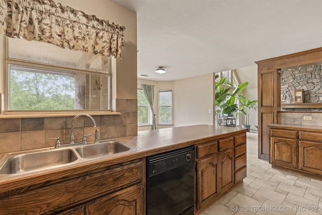4157 New Prue Rd, Sand Springs, OK 74063 - kitchen featuring black dishwasher, a sink, backsplash, brown cabinetry, and a peninsula