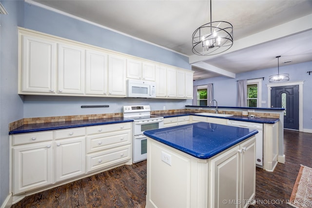 1020 N 3rd, Durant, OK 74701 - kitchen with white appliances, a peninsula, a kitchen island, a sink, and dark wood-style floors