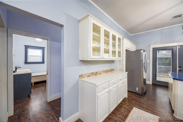 1020 N 3rd, Durant, OK 74701 - kitchen featuring stainless steel fridge, dark wood-type flooring, glass insert cabinets, a sink, and white cabinets
