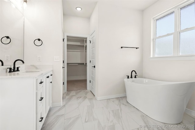 13634 S 21st Ct E, Bixby, OK 74008 - bathroom featuring vanity, a freestanding tub, marble finish floors, and a walk in closet
