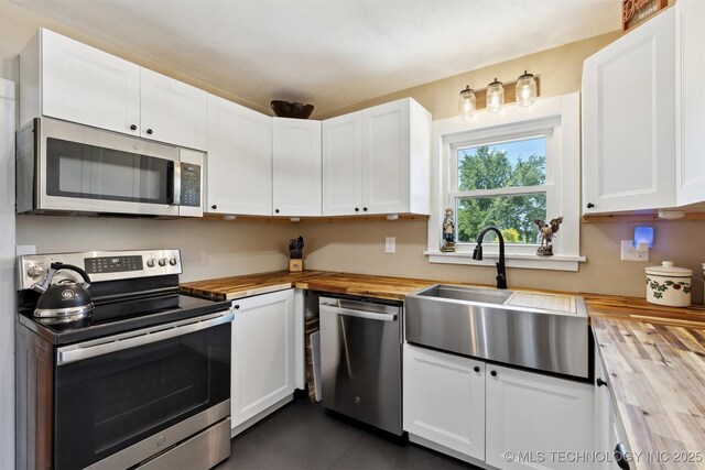 780452 S 3530, Cushing, OK 74023 - kitchen featuring wood counters, appliances with stainless steel finishes, a sink, and white cabinets