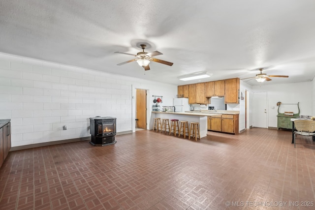370463 E 5750th Rd, Terlton, OK 74081 - kitchen with ceiling fan, a wood stove, light countertops, freestanding refrigerator, and a textured ceiling