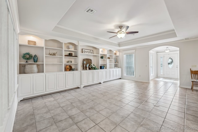 370463 E 5750th Rd, Terlton, OK 74081 - empty room with a tray ceiling, arched walkways, a ceiling fan, light tile patterned flooring, and built in shelves