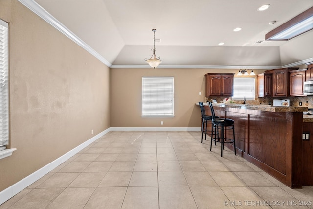 28744 N 3964th Rd, Ochelata, OK 74051 - kitchen featuring vaulted ceiling, stainless steel microwave, a kitchen bar, crown molding, and tasteful backsplash