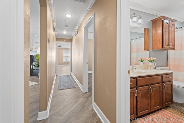 28744 N 3964th Rd, Ochelata, OK 74051 - corridor with crown molding, baseboards, light wood-style flooring, and a sink