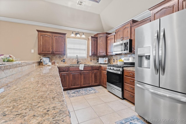 28744 N 3964th Rd, Ochelata, OK 74051 - kitchen with appliances with stainless steel finishes, light tile patterned floors, decorative backsplash, a sink, and vaulted ceiling
