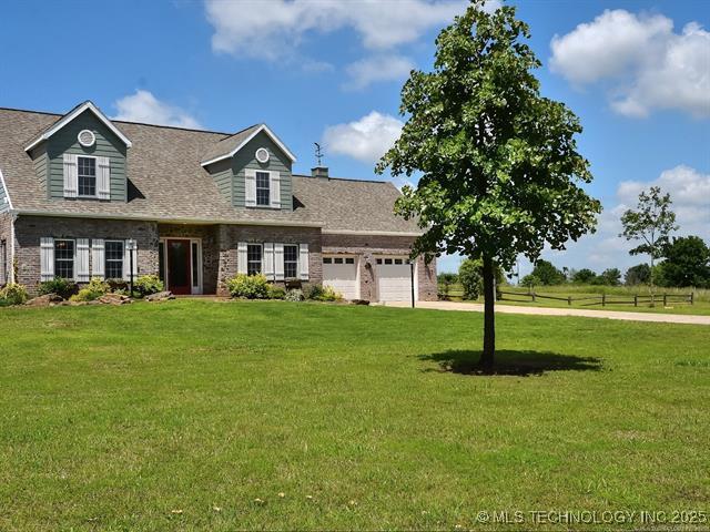 2982 S 294th E Ave, Broken Arrow, OK 74014 - cape cod-style house featuring an attached garage, a front yard, brick siding, and a shingled roof