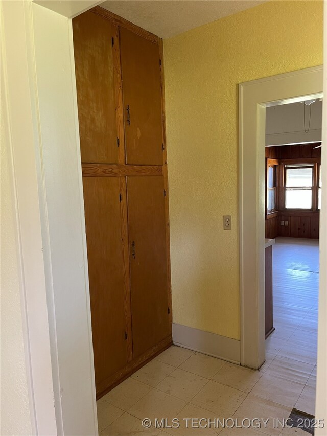 701 NW 3rd St, Stigler, OK 74462 - corridor with baseboards, light floors, and a textured wall