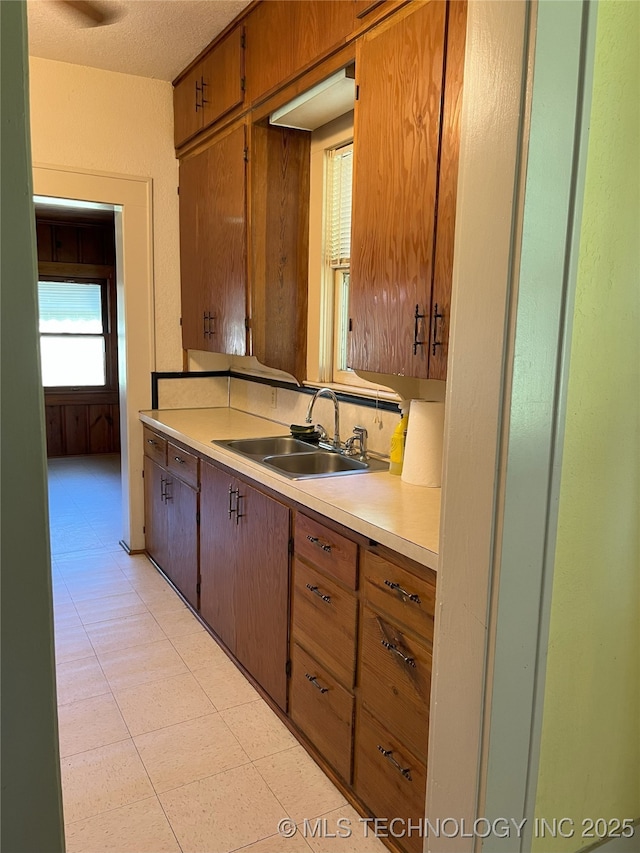 701 NW 3rd St, Stigler, OK 74462 - kitchen with a sink, light countertops, and brown cabinetry
