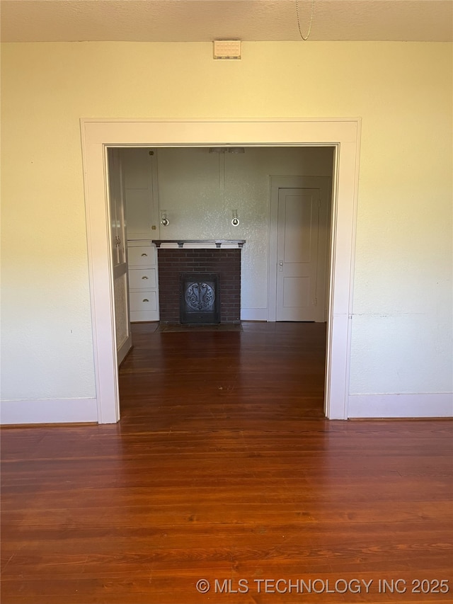 701 NW 3rd St, Stigler, OK 74462 - hallway featuring baseboards and dark wood finished floors