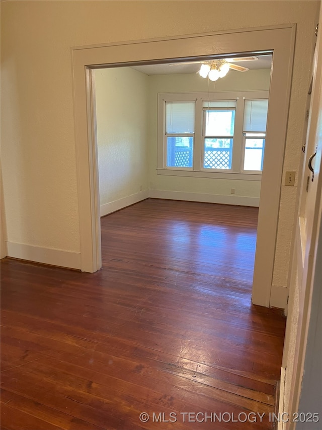 701 NW 3rd St, Stigler, OK 74462 - empty room with dark wood-style floors, baseboards, and ceiling fan