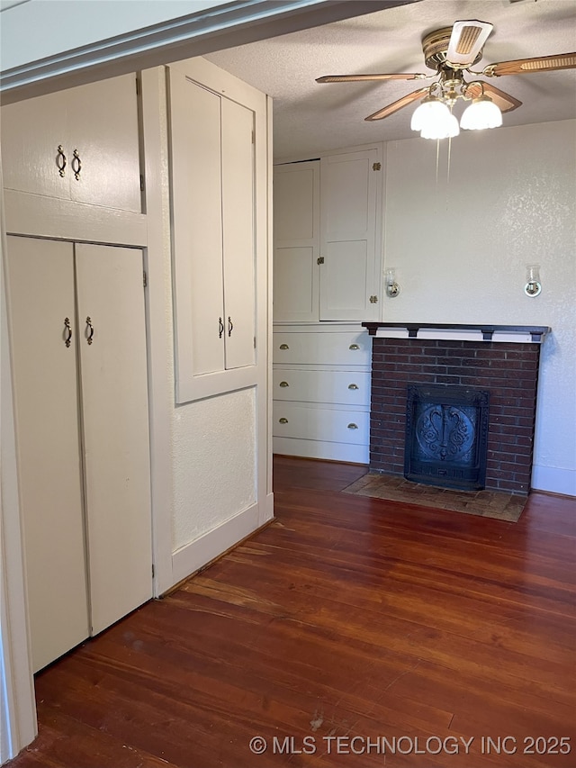 701 NW 3rd St, Stigler, OK 74462 - unfurnished living room with wood finished floors, a fireplace, ceiling fan, and baseboards