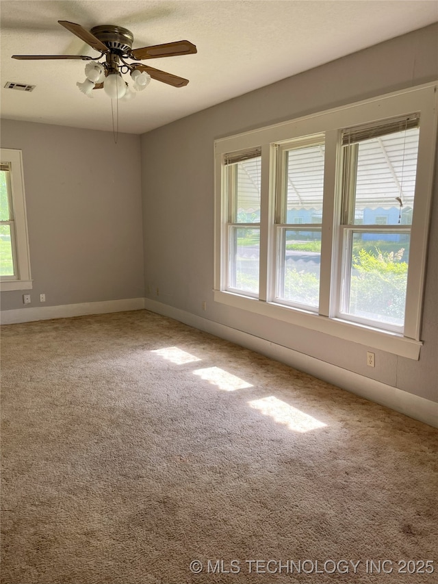 701 NW 3rd St, Stigler, OK 74462 - empty room with healthy amount of natural light, ceiling fan, and carpet