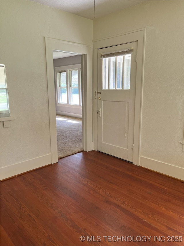 701 NW 3rd St, Stigler, OK 74462 - entryway featuring dark wood finished floors and baseboards