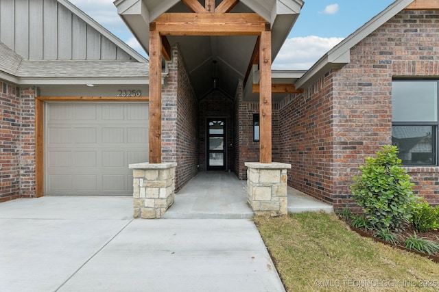 23250 E 106th Pl S, Broken Arrow, OK 74014 - property entrance featuring concrete driveway, brick siding, board and batten siding, and a garage