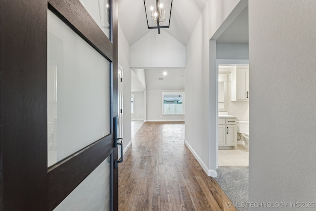 23250 E 106th Pl S, Broken Arrow, OK 74014 - hallway featuring vaulted ceiling, a chandelier, and wood finished floors