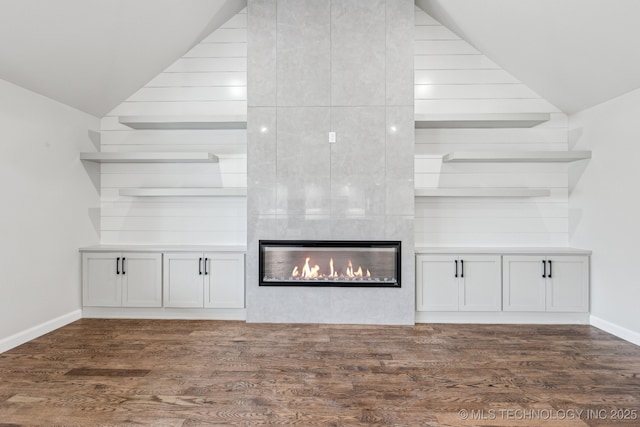 23250 E 106th Pl S, Broken Arrow, OK 74014 - unfurnished living room with vaulted ceiling, wood finished floors, a tiled fireplace, and baseboards
