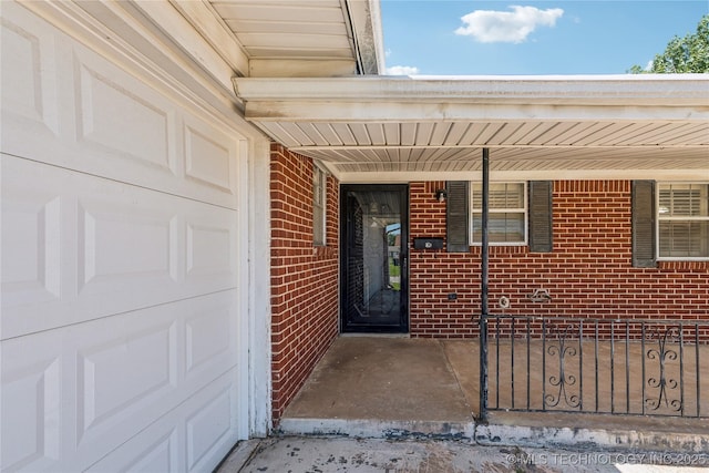 8805 E 46th Pl, Tulsa, OK 74145 - entrance to property with brick siding, an attached garage, and covered porch