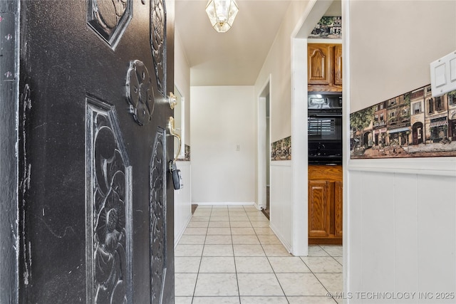 8805 E 46th Pl, Tulsa, OK 74145 - kitchen with black oven, light tile patterned flooring, and wainscoting